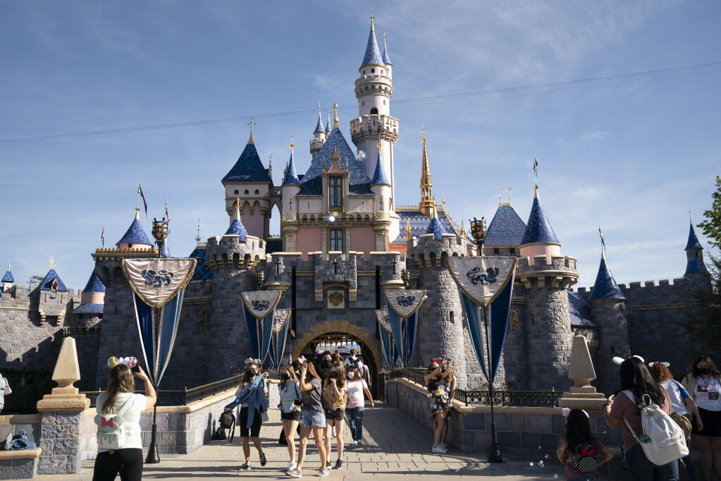 FILE - In this Friday, April 30, 2021, file photo, visitors exit The Sleeping Beauty Castle at Disneyland in Anaheim, Calif.  (AP Photo/Jae C. Hong, File)