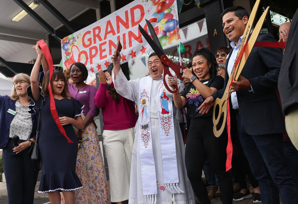 Marcos Suarez, right, market owner Armie Rivera, Father Alvin Villaruel and others celebrate the grand opening of Kabayan Filipino Market in Rohnert Park, Friday, Sept. 8, 2023. (Christopher Chung / The Press Democrat)