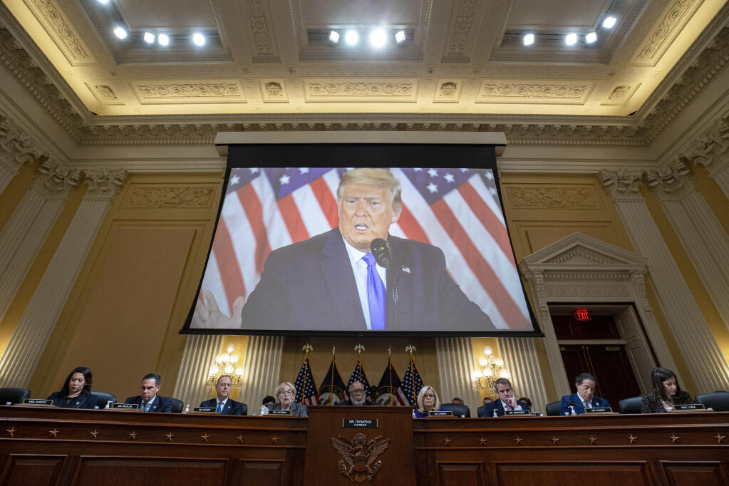 A video of former President Donald Trump is shown on a screen as the House select committee investigating the Jan. 6 attack on the U.S. Capitol holds its final meeting on Capitol Hill in Washington, Monday, Dec. 19, 2022. From left, Rep. Stephanie Murphy, D-Fla., Rep. Pete Aguilar, D-Calif., Rep. Adam Schiff, D-Calif., Rep. Zoe Lofgren, D-Calif., Chairman Bennie Thompson, D-Miss., Vice Chair Liz Cheney, R-Wyo., Rep. Adam Kinzinger, R-Ill., Rep. Jamie Raskin, D-Md., and Rep. Elaine Luria, D-Va.. (Al Drago/Pool Photo via AP)