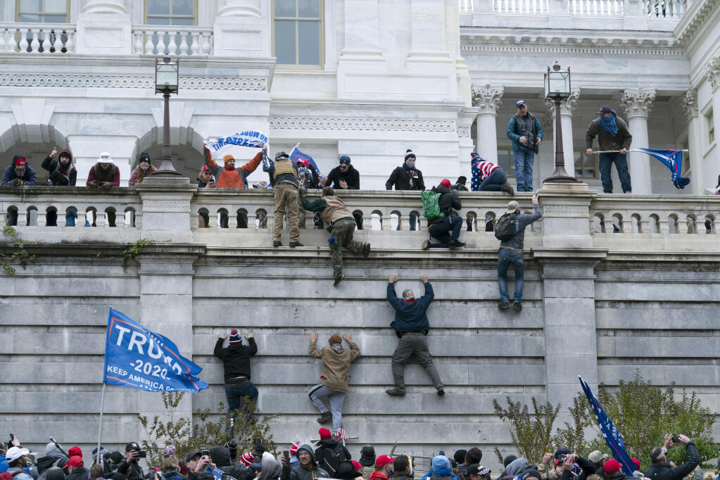 FILE - Supporters of President Donald Trump climb the west wall of the the U.S. Capitol on Jan. 6, 2021, in Washington. (AP Photo/Jose Luis Magana, File)