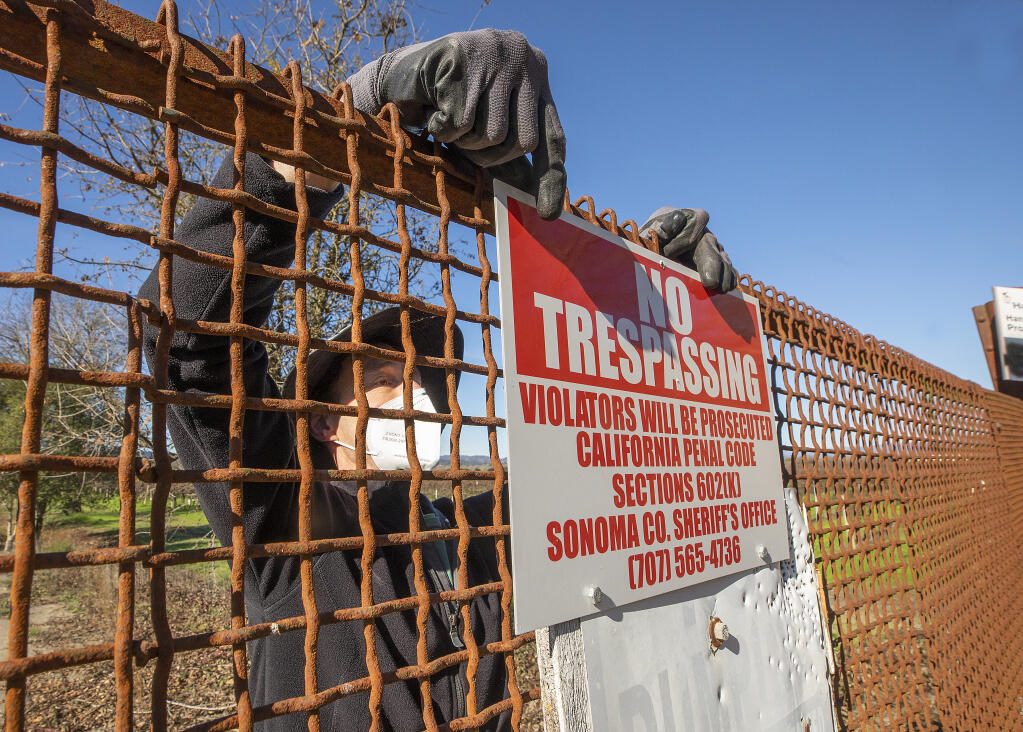Russian Riverkeeper Don McEnhill installs “no trespassing” signs at the entrance to Hanson Ponds off Eastside Road west of Windsor. Local fisherman have busted through gates and damaged the signs while illegally accessing the protected area along the Russian River. (John Burgess/The Press Democrat)