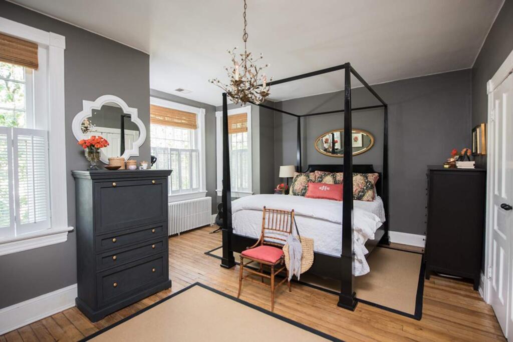 The master bedroom has an airy, pencil-post canopy bed from Restoration Hardware Outlet that the Hoburgs painted black. The chandelier with a leaf motif is from Ballard Designs. The oval mirror over the bed is a family antique. (MUST CREDIT: Mike Morgan/For The Washington Post)