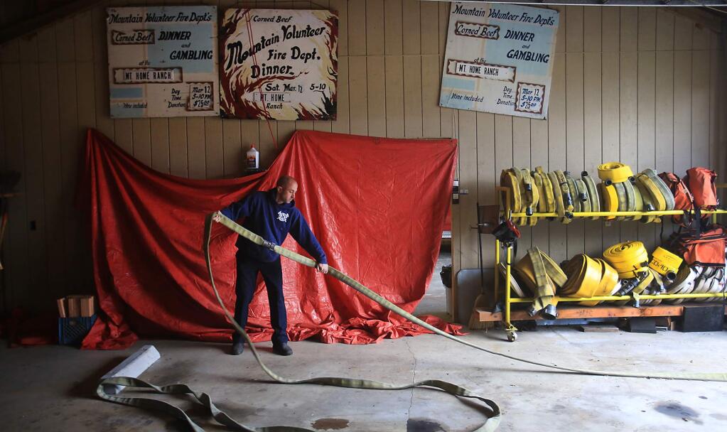 Mountain volunteer fire captain and EMT Jeff Lemelin sets up for a drill at Mountain Volunteer Fire Company, Tuesday March 21, 2017. (Kent Porter / The Press Democrat) 2017