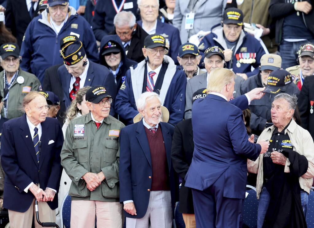 U.S. President Donald Trump greets World War II veterans during a ceremony to mark the 75th anniversary of D-Day at the Normandy American Cemetery in Colleville-sur-Mer, Normandy, France, Thursday, June 6, 2019. World leaders are gathered Thursday in France to mark the 75th anniversary of the D-Day landings. (AP Photo/David Vincent)