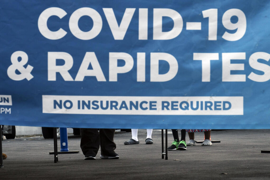 People wait to get tested for COVID-19 at a pop-up testing site in Los Angeles, Monday, Dec. 20, 2021. (AP Photo/Jae C. Hong)