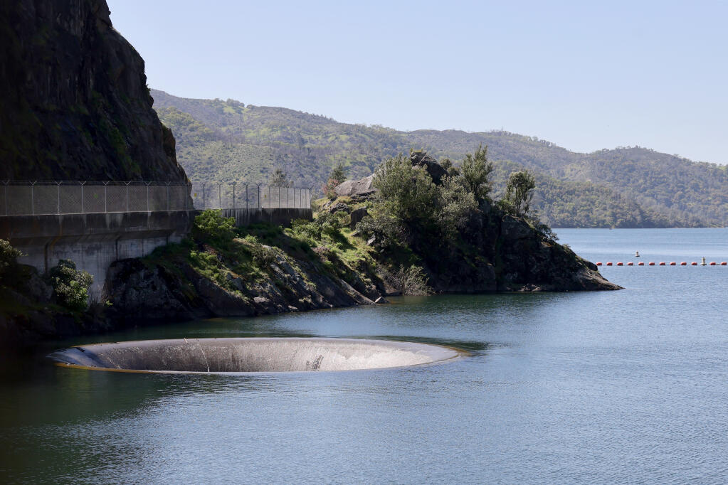 Water trickles over edge of the Morning Glory Spillway, also known as the “Glory Hole” at Lake Berryessa in Napa County, Tuesday, April 2, 2024. (Beth Schlanker / The Press Democrat file)