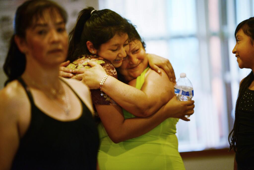 Alejandra Cervantes, who founded the nonprofit Nuestra Voz at the end of a Zumba class with instructor Maricella Calderón, left, Theresa Perez, 10 far right, and hugging Alondra Perez, 14, at the low-income housing units of Spring Village which serve Latino families in Sonoma. April 18, 2016. (Photo: Erik Castro/for The Press Democrat)
