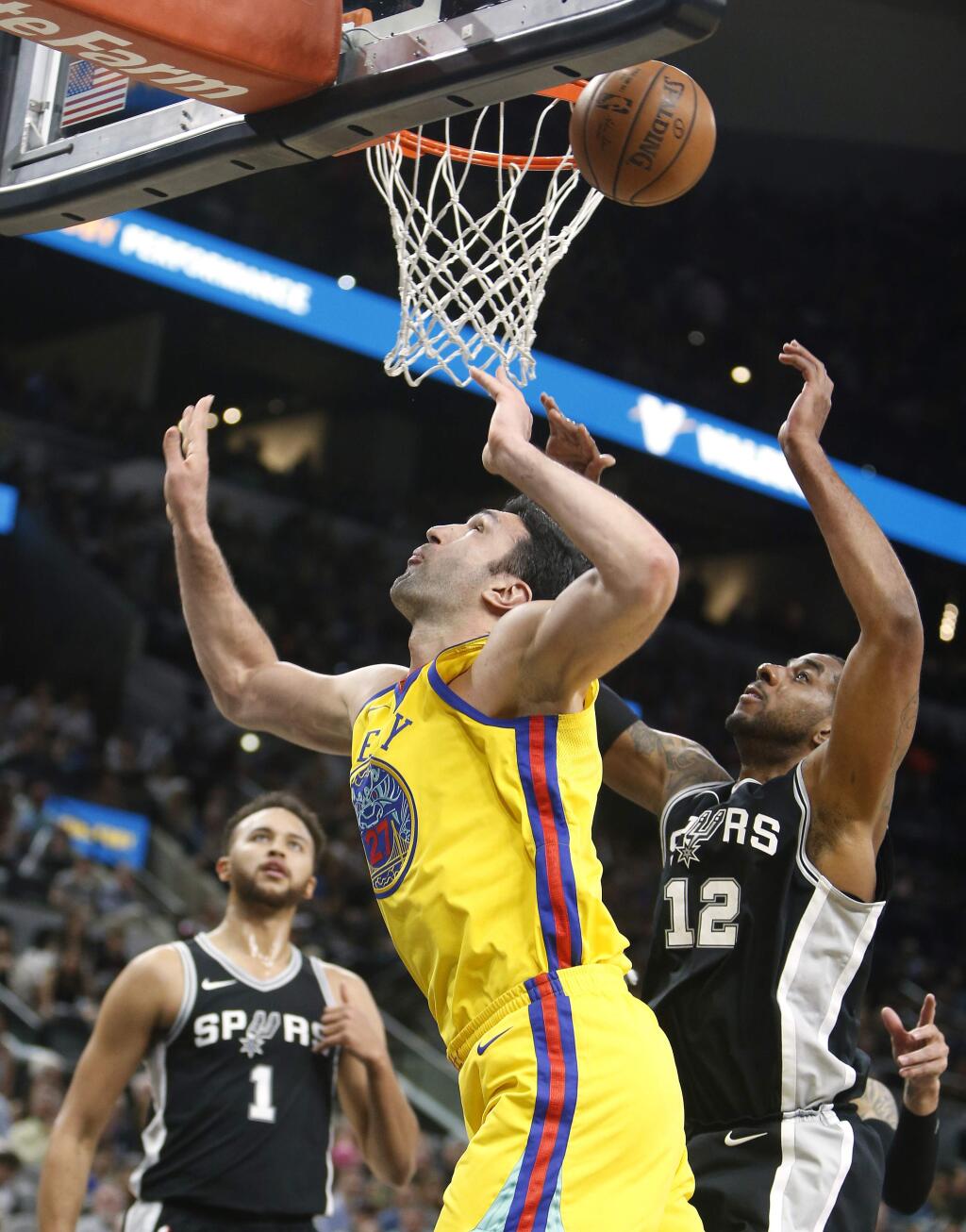 Golden State Warriors center Zaza Pachulia (27) has his shot blocked by San Antonio Spurs forward LaMarcus Aldridge (12) during the first half of an NBA game, Monday, March 19, 2018, in San Antonio. (AP Photo/Ronald Cortes)