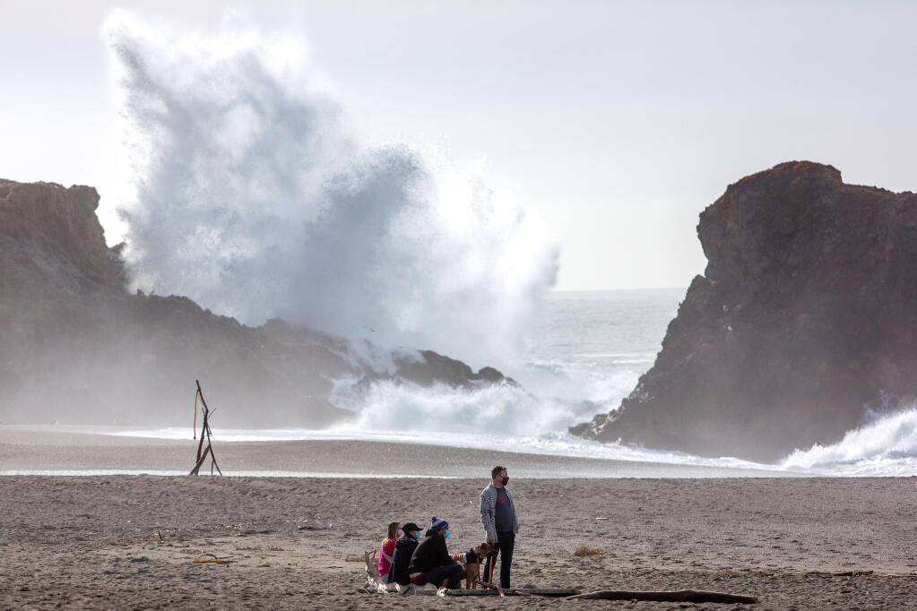 From a safe distance, Peter O'Farrell, at right, Stephen Humble, Melissa Ramos, and Monique Boyer watch large waves come ashore at Wright's Beach in Bodega Bay, California, on Friday, Jan. 1, 2021. (Alvin A.H. Jornada / The Press Democrat)