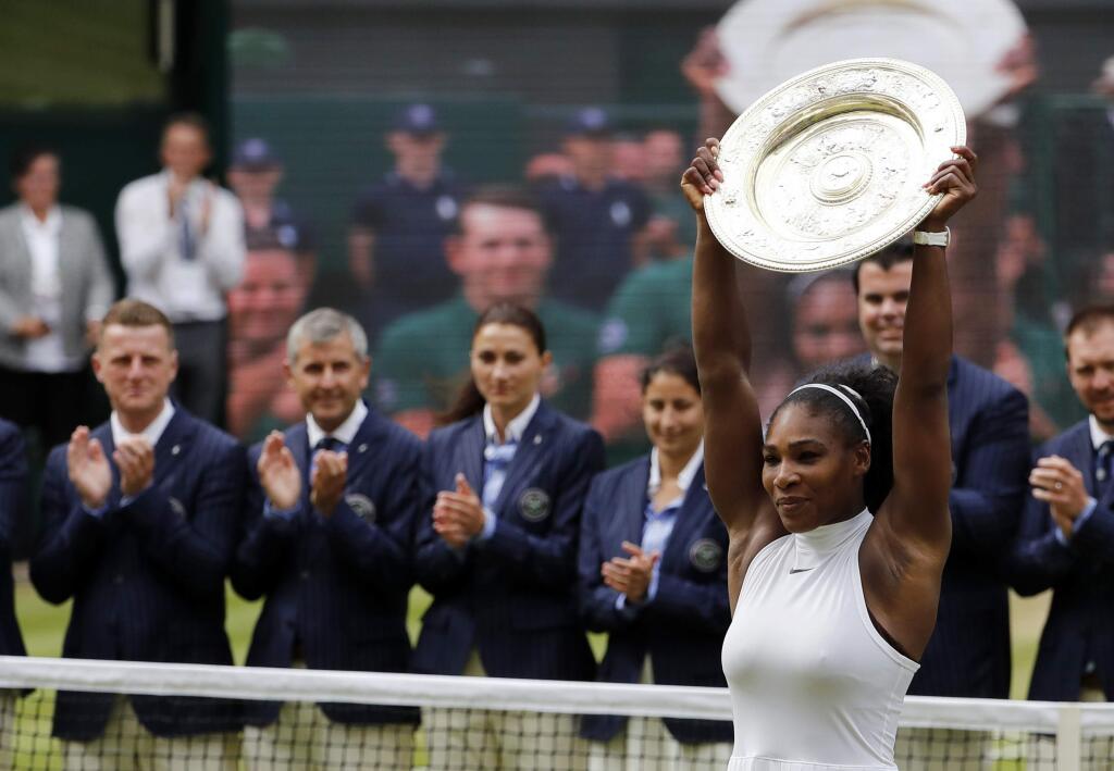 Serena Williams of the U.S raises the trophy after beating Angelique Kerber of Germany in the women's singles final on day thirteen of the Wimbledon Tennis Championships in London, Saturday, July 9, 2016. (AP Photo/Ben Curtis)
