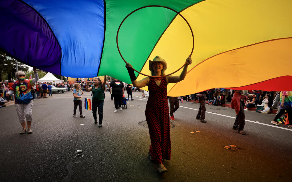 Jen Bredesen from Sebastopol supports the middle of a large rainbow flag during the Sonoma County Pride Parade and Festival in downtown Santa Rosa, Saturday, June 4, 2022. The flag was part of the Community Church of Sebastopol entry.  (Kent Porter / The Press Democrat) 2022