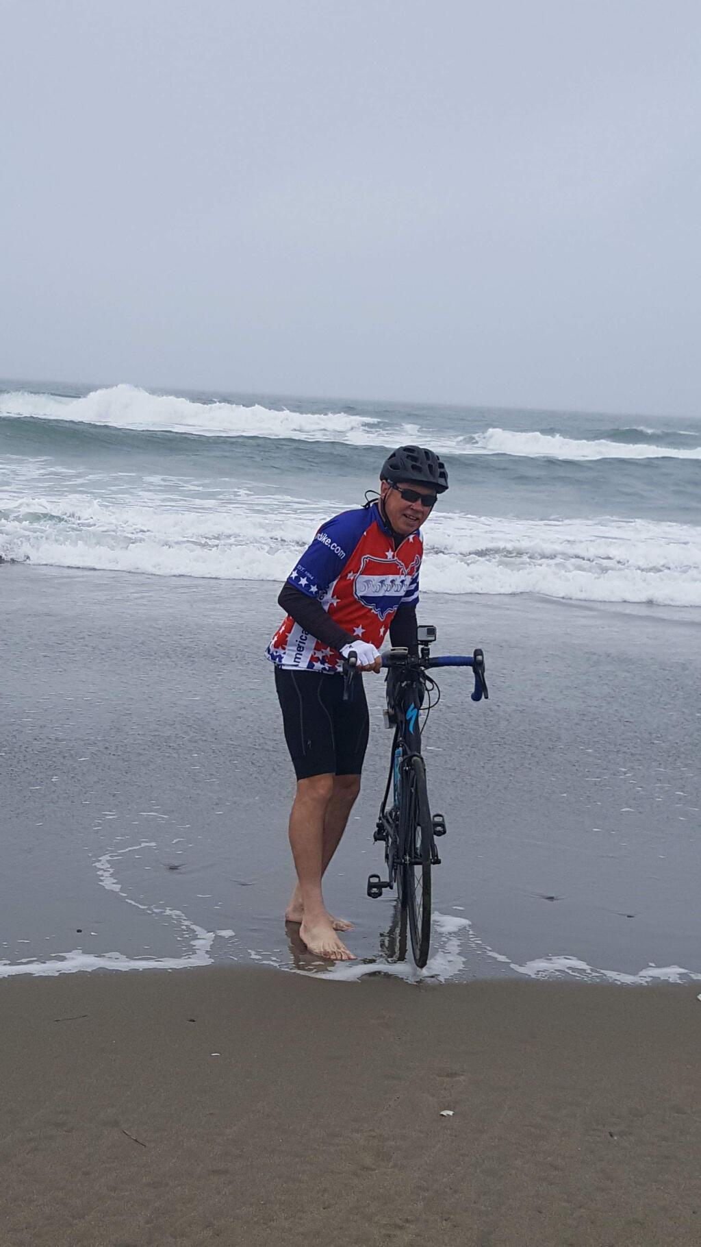 SUBMITTED PHOTOPetaluman Doug Sanders dips his back wheel in the Pacific Ocean at the start of a 3,829-mile cross country ride.