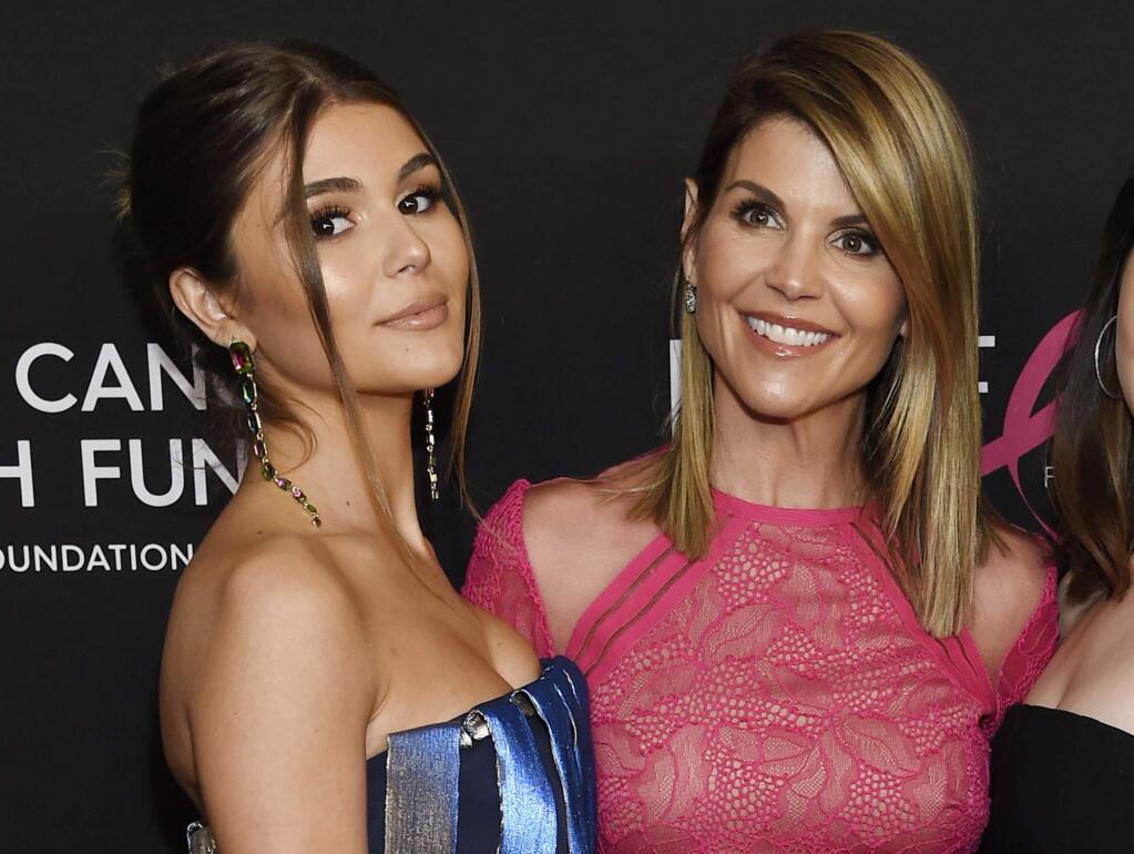 FILE - In this Feb. 28, 2019 file photo, actress Lori Loughlin poses with her daughter Olivia Jade Giannulli, left, at the 2019 'An Unforgettable Evening' in Beverly Hills, Calif. Felicity Huffman and Loughlin have worked steadily as respected actresses and remained recognizable if not-quite-A-list names for decades. Neither has ever had a whiff of criminality or scandal tied to their name until both were charged with fraud and conspiracy Tuesday along with dozens of others in a scheme that according to federal prosecutors saw wealthy parents pay bribes to get their children into some of the nation's top colleges. (Photo by Chris Pizzello/Invision/AP, File)