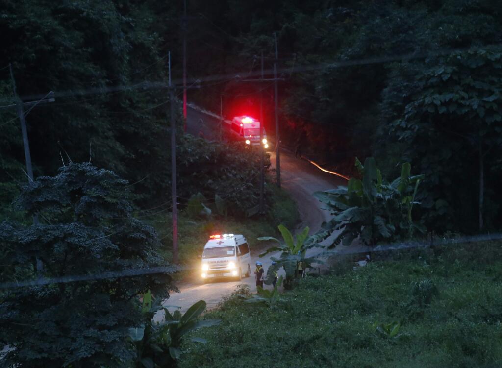 Two ambulances with flashing lights leaves the cave rescue area in Mae Sai, Chiang Rai province, northern Thailand, Monday, July 9, 2018. The ambulance has left the cave complex area hours after the start of the second phase of an operation to rescue a youth soccer team trapped inside the cave for more than two weeks. (AP Photo/Sakchai Lalit)