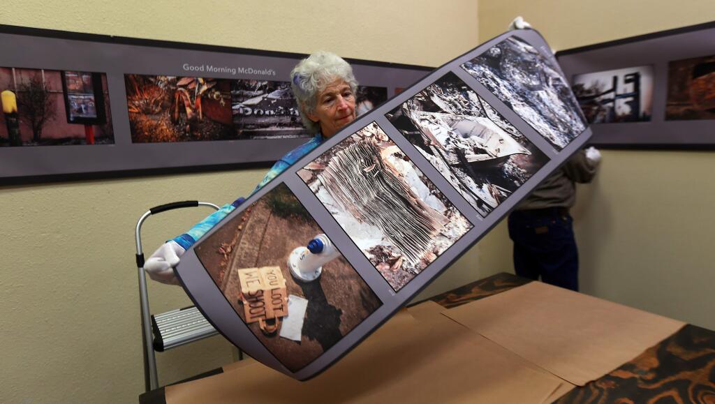 Photographer Penny Wolin hangs three image series from the aftermath of the Tubbs Fire at Calabi Gallery in Santa Rosa on Friday. (John Burgess/The Press Democrat)