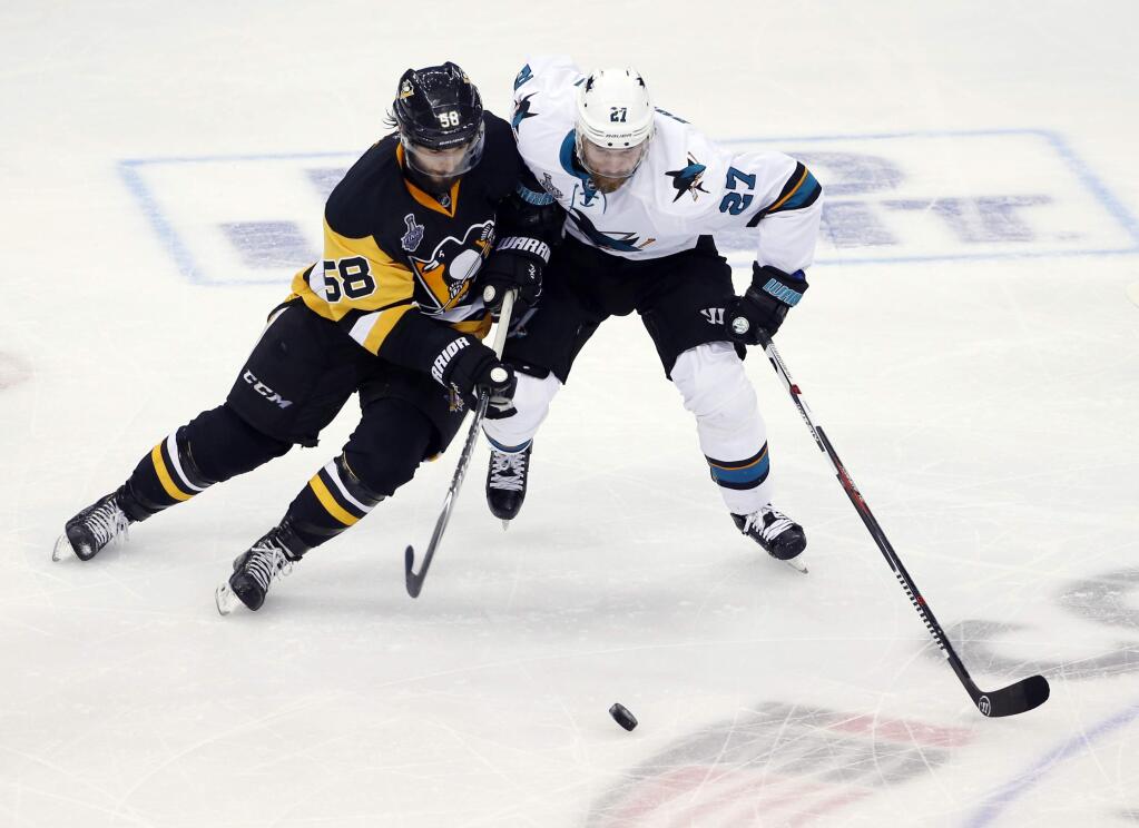 Pittsburgh Penguins' Kris Letang and San Jose Sharks' Joonas Donskoi compete for the puck during the third period of Game 5 of the Stanley Cup Finals on Thursday, June 9, 2016, in Pittsburgh. (AP Photo/Gene J. Puskar)