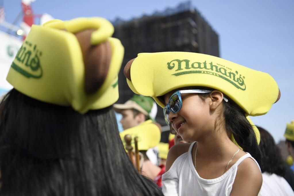 Amber Castillo, 6, attends Nathan's Famous July Fourth hot dog eating contest, Thursday, July 4, 2019, in New York's Coney Island. (AP Photo/Sarah Stier)