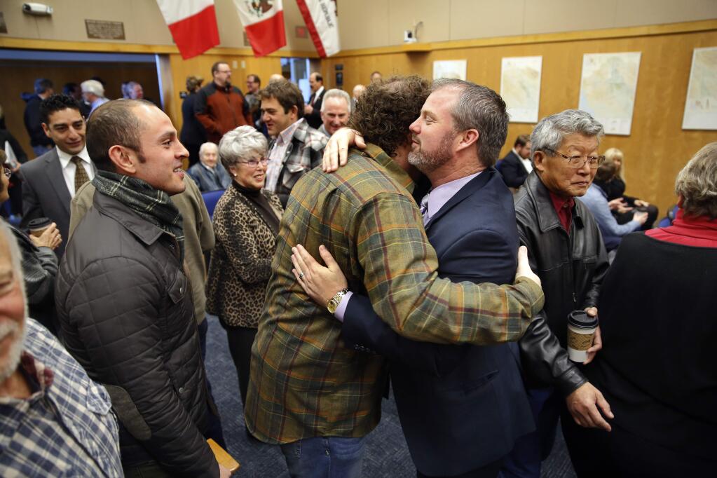 4th District Supervisor James Gore, right, hugs his brother Tom during the Sonoma County Board of Supervisors meeting in Santa Rosa, California on Tuesday, January 6, 2015. (BETH SCHLANKER/ The Press Democrat)