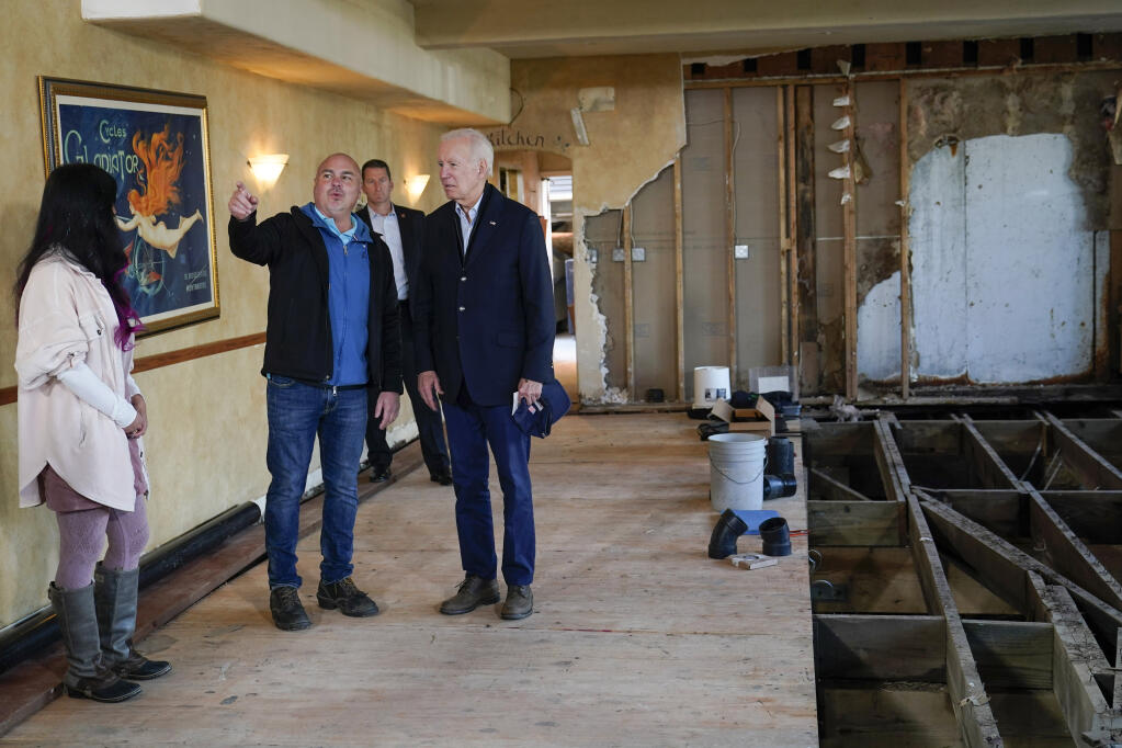 President Joe Biden talks with Paradise Beach Grille co-owners Chuck Maier and Ally Gotlieb, left, as he visits with business owners and local residents in Capitola, Calif., Thursday, Jan 19, 2023, to survey recovery efforts following a series of severe storms. (AP Photo/Susan Walsh)