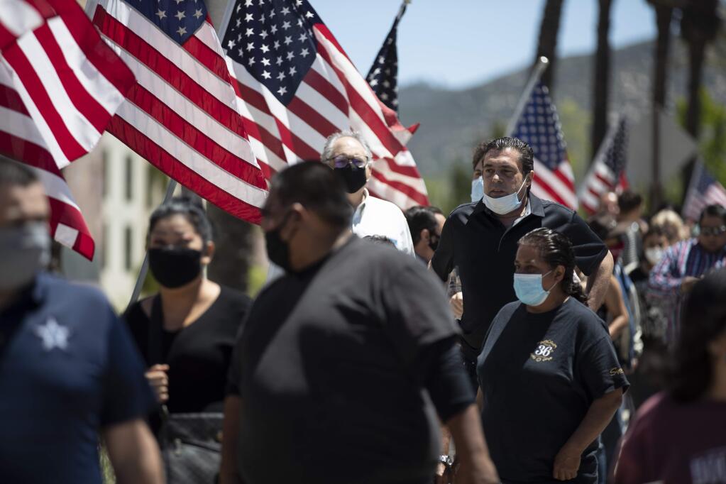 People wait in line at the entrance to the Viejas Casino and Resort as it reopens Monday, May 18, 2020, in Alpine, Calif. The casino is one of several on tribal lands in Southern California set to reopen this week. (AP Photo/Gregory Bull)