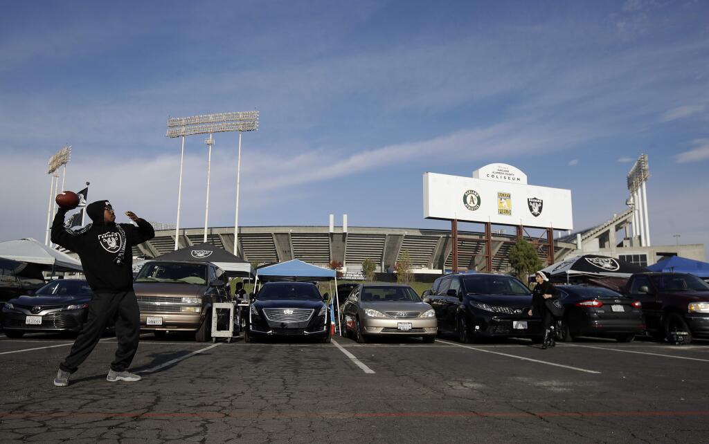 Fans tailgate outside of Oakland Alameda County Coliseum before an NFL football game between the Oakland Raiders and the Pittsburgh Steelers in Oakland, Calif., Sunday, Dec. 9, 2018. (AP Photo/Jeff Chiu)