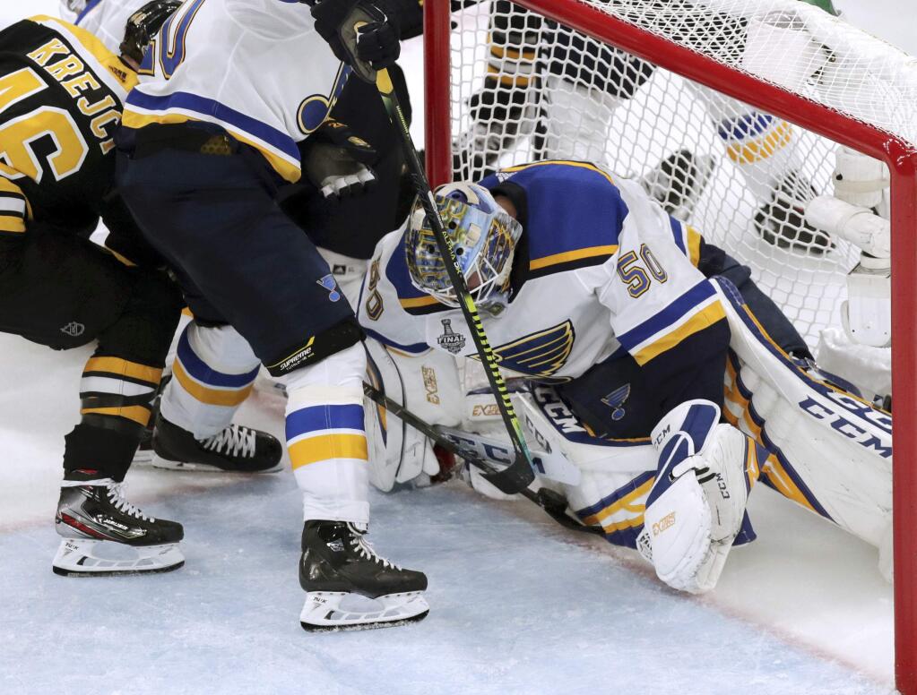 St. Louis Blues goaltender Jordan Binnington, right, stops a shot at the goal line as the Boston Bruins' David Krejci, left, pokes at it during the third period in Game 5 of the NHL Stanley Cup Final, Thursday, June 6, 2019, in Boston. A video review confirmed there was no goal on the play. (AP Photo/Charles Krupa)