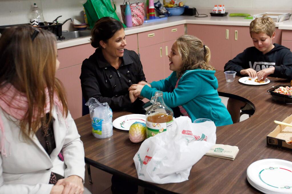 North County Consortium principal Vicki Long, left, Cesar Chavez Elementary School principal Rebekah Rocha, and her children Mercy, 8, and Jerry, 12,share food and conversation during the first meeting of a support group for children who have siblings with special needs, at Windsor Creek Elementary School in Windsor, California, on Thursday, January 18, 2018. (Alvin Jornada / The Press Democrat)