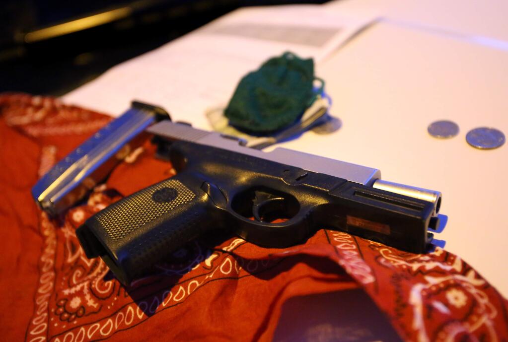 A 9-millimeter handgun and red bandana were among items found in Joe Carlos Suazo's possession at the time of his arrest, in Santa Rosa on Thursday, August 21, 2014. Suazo had felony warrants and was on Sonoma County's top ten most wanted list at the time of his arrest.(Christopher Chung/ The Press Democrat)