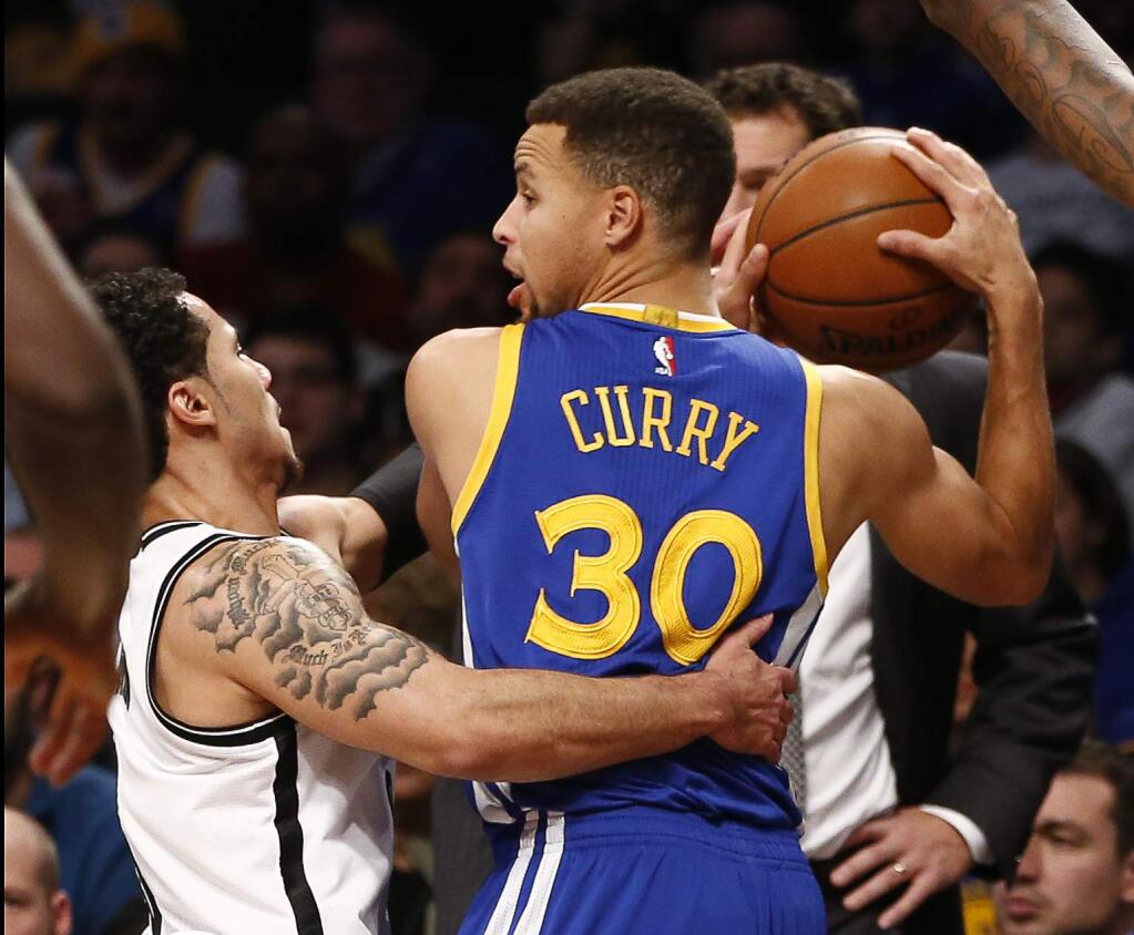 Brooklyn Nets guard Shane Larkin, left, defends as Golden State Warriors guard Stephen Curry (30) looks to pass in the first half of an NBA basketball game, Sunday, Dec. 6, 2015, in New York. (AP Photo/Kathy Willens)