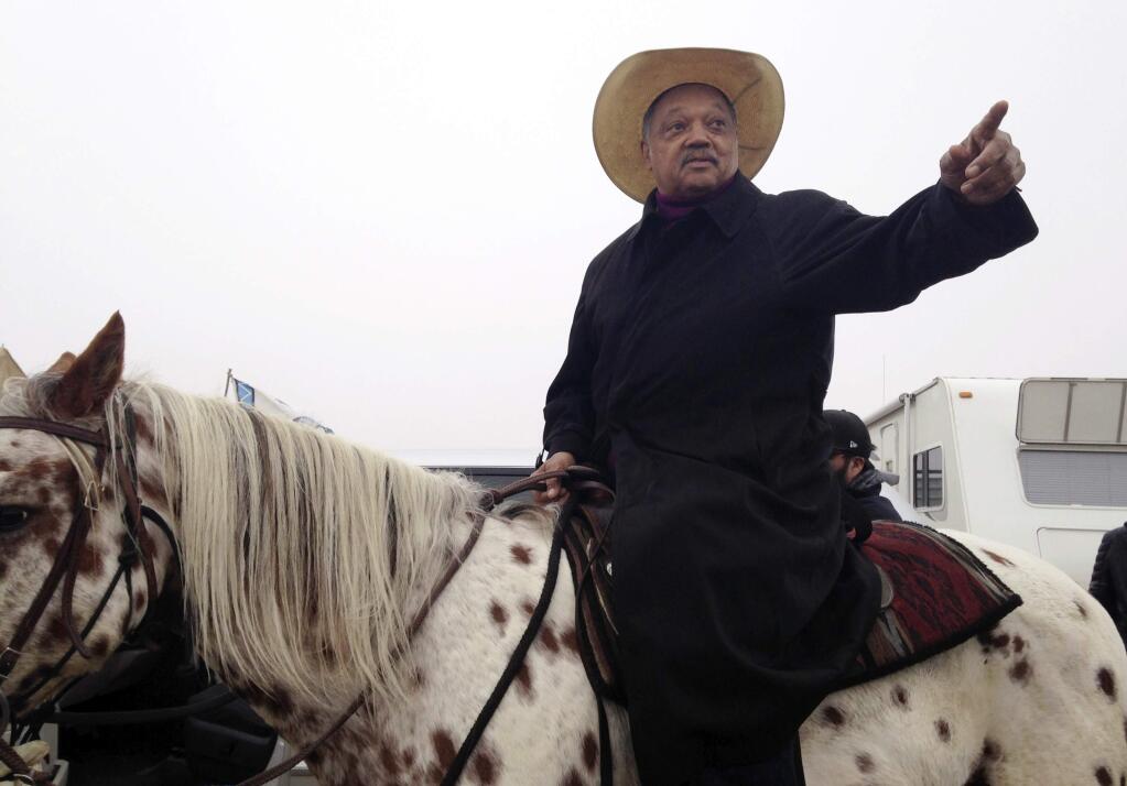 Civil rights activist Jesse Jackson sits atop a horse Wednesday, Oct. 26, 2016, while visiting the protest camp against the Dakota Access oil pipeline outside Cannon Ball, N.D. Jackson said he came 'to pray together, protest together and if necessary, go to jail together.' (AP Photo/James MacPherson)