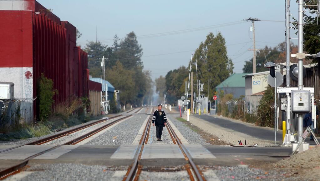 A pedestrian walks along the SMART tracks near West 8th Street in Santa Rosa in 2013. (CHRISTOPHER CHUNG/ PD FILE)