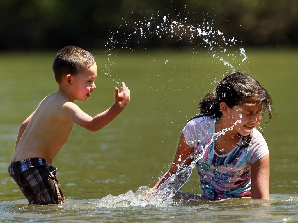 WARM WEATHER FUN: Kevin Moreno fights back in a splash fight with his sister, Lindy, on a hot day at Johnson's Beach in Guerneville in 2012. (JOHN BURGESS/ PD FILE)