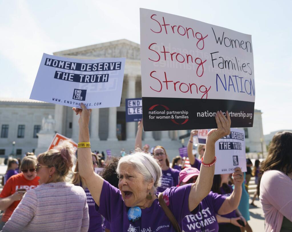 A woman protests outside the Supreme Court Building on Capitol Hill in in Washington, Tuesday, June 26, 2018. She is against facilities established by pro-life organizations around the country that counsel women against abortion. The Supreme Court effectively put an end Tuesday to a California law that forces anti-abortion crisis pregnancy centers to provide information about abortion. The 5-4 ruling also casts doubts on similar laws in Hawaii and Illinois.(AP Photo/Carolyn Kaster)