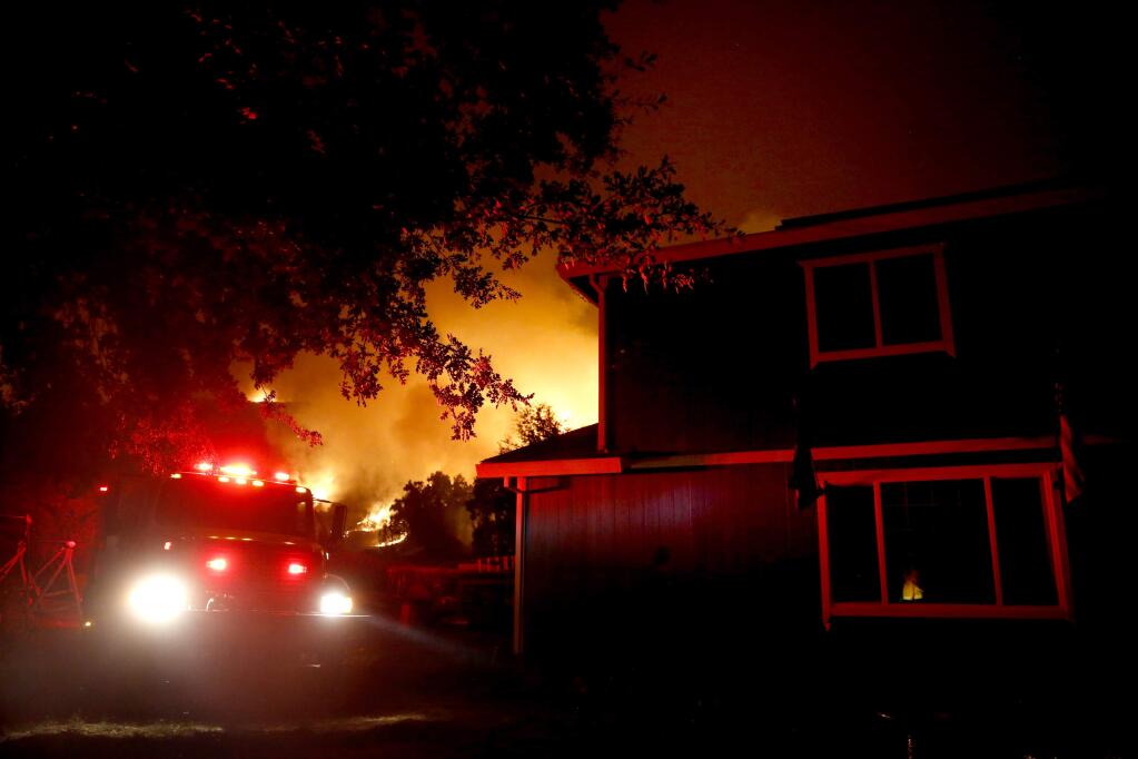 A firetruck sits parked near a residence in Upper Lake while the Ranch fire, part of the Mendocino Complex fires, burns on Sunday. (BETH SCHLANKER / Press Democrat)
