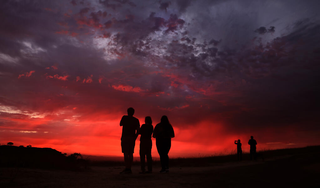 Odeh, Susan and Rania Saba of Petaluma take in a thunderstorm-infused sunset at Crane Creek Regional Park near Rohnert Park, Thursday, Sept. 9, 2021. At 2 a.m. Sunday, the clocks roll back an hour and the bleak winter days descend. (Kent Porter / The Press Democrat)