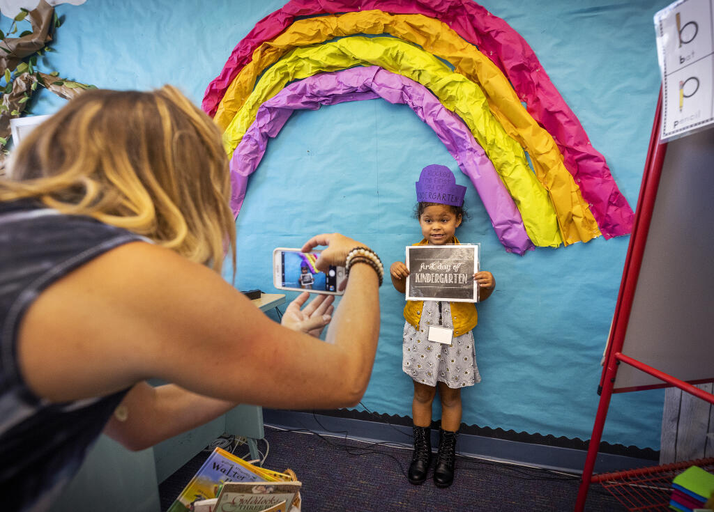 Kindergarten teacher Brittany Beseda takes a photo of Naia Reed, 5, on the first day of school at John B. Riebli School in Santa Rosa Thursday, August 11, 2022. (John Burgess/The Press Democrat)