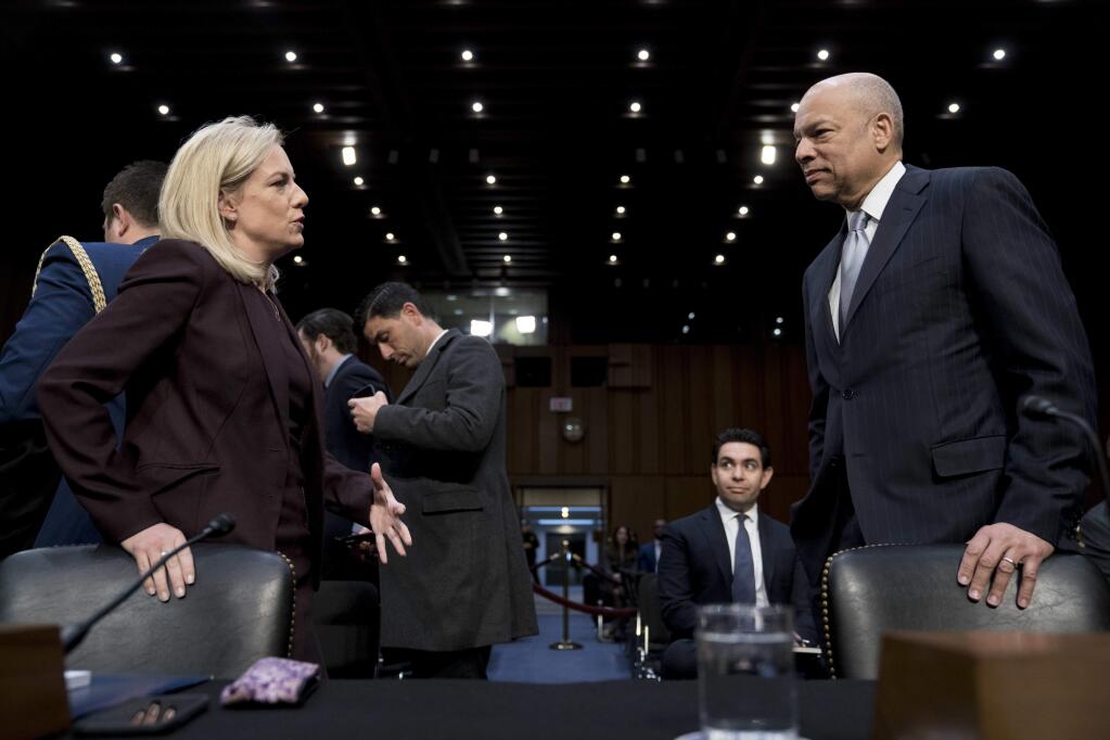 Homeland Security Secretary Kirstjen Nielsen, left, and former Homeland Security Secretary Jeh Johnson, right, speak before a Senate Intelligence Committee hearing on election security on Capitol Hill in Washington, Wednesday, March 21, 2018. (AP Photo/Andrew Harnik)