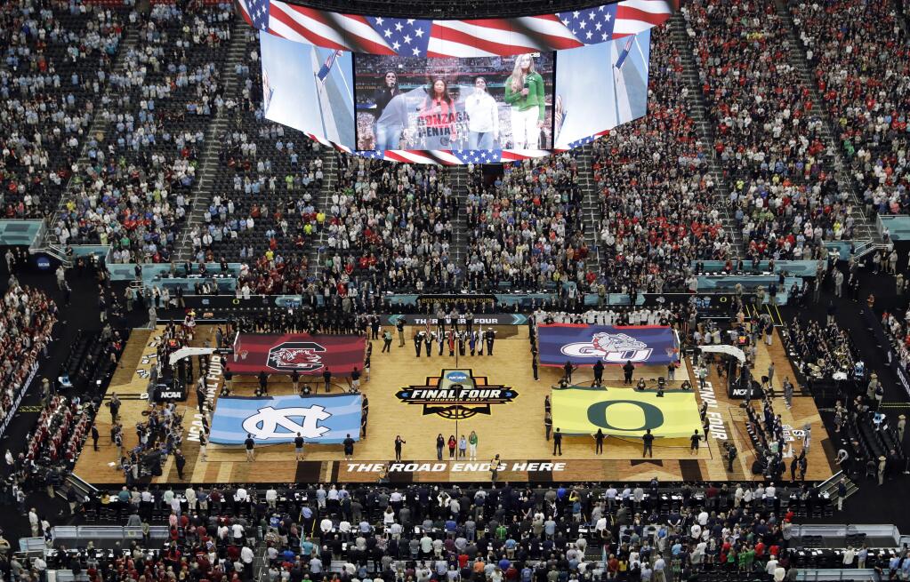 In this April 1, 2017, file photo, fans stand as they observe the national anthem before the NCAA Final Four in Glendale, Arizona. NCAA President Mark Emmert says tournament games will be played without fans in the arenas because of concerns about the spread of coronavirus. (AP Photo/Morry Gash, File)
