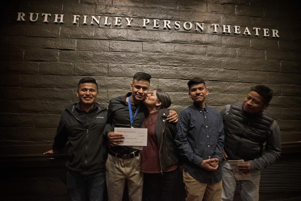 Eric Guzman Leyva, 17, receives a kiss from his mother, Yolanda Guzman, while posing for a photo with his siblings Rene Guzman, far left, and Anthony Guzman and his father, Adolfo Guzman, far right, after The Press Democrat's Youth Service Awards on April 10. (Erik Castro / For The Press Democrat)
