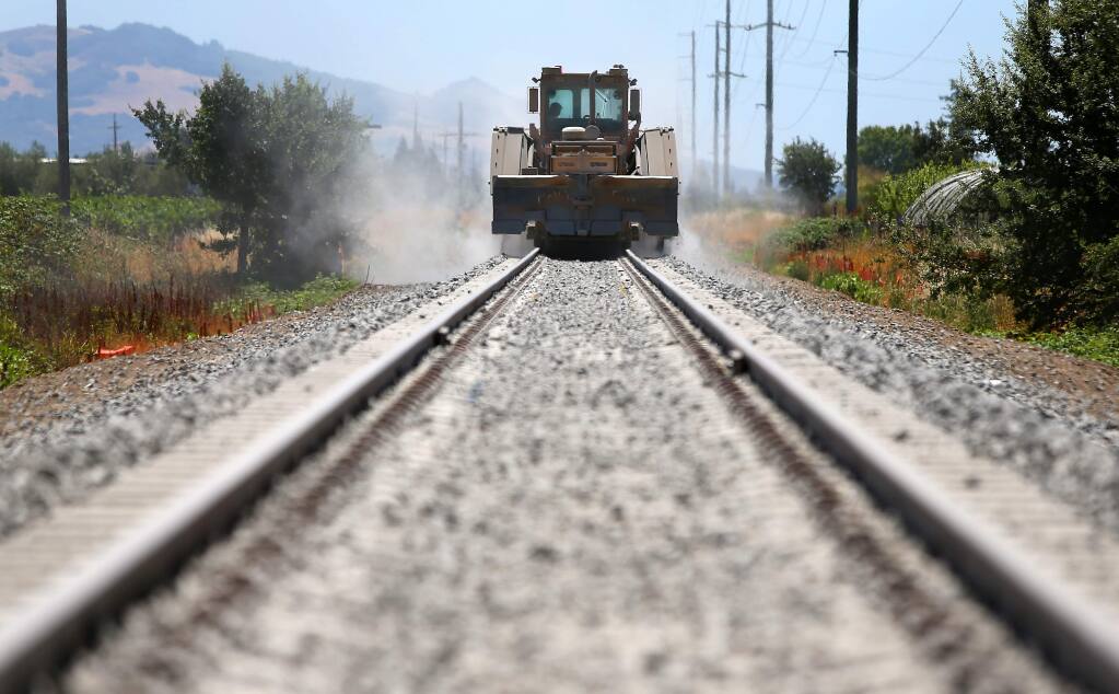 A machine distributes ballast on the Sonoma-Marin Area Rail Transit line between Fulton and San Miguel roads in Santa Rosa. (Christopher Chung / PD FILE)