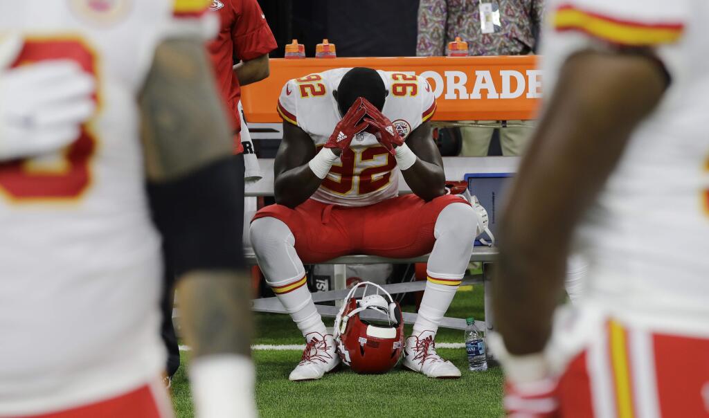 FILE - In this Oct. 8, 2017, file photo, Kansas City Chiefs linebacker Tanoh Kpassagnon (92) sits on the bench during the national anthem before an NFL football game against the Houston Texans, in Houston. NFL owners have approved a new policy aimed at addressing the firestorm over national anthem protests, permitting players to stay in the locker room during the 'The Star-Spangled Banner' but requiring them to stand if they come to the field.The decision was announced Wednesday, May 23, 2018, by NFL Commissioner Roger Goodell during the league's spring meeting in Atlanta.(AP Photo/David J. Phillip, File)