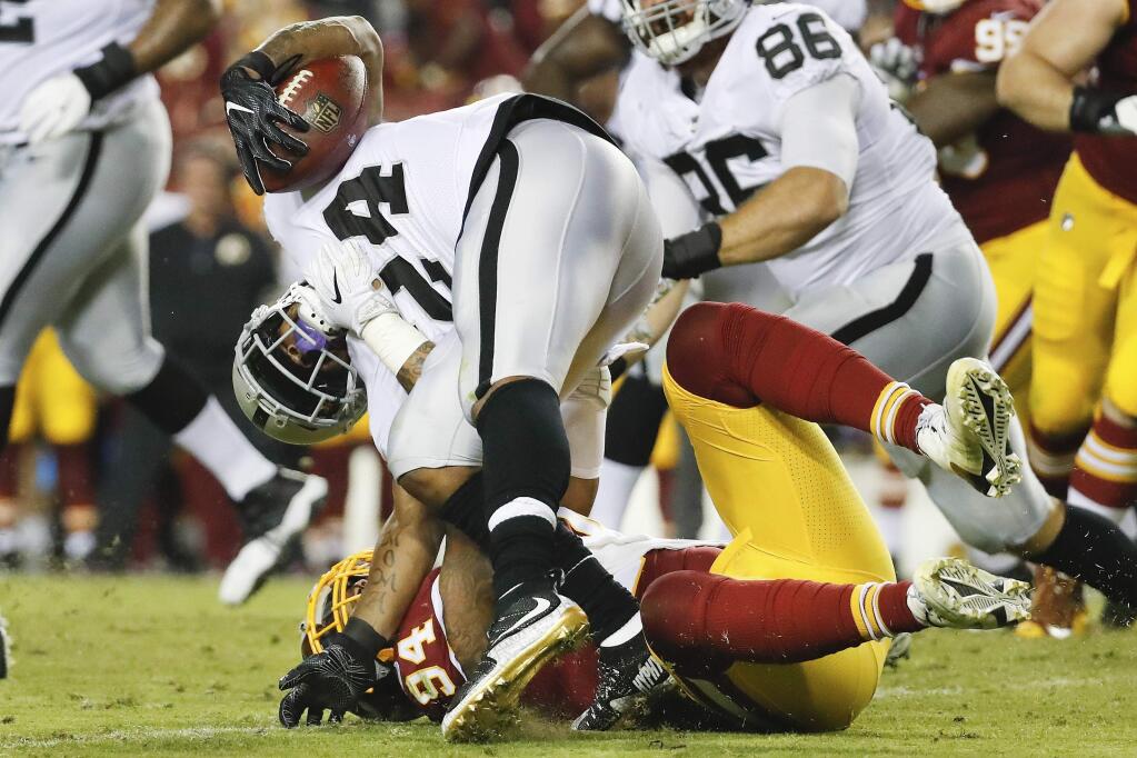 Oakland Raiders running back Marshawn Lynch (24) is stopped by Washington Redskins outside linebacker Preston Smith (94) during the first half of an NFL football game in Landover, Md., Sunday, Sept. 24, 2017. (AP Photo/Alex Brandon)