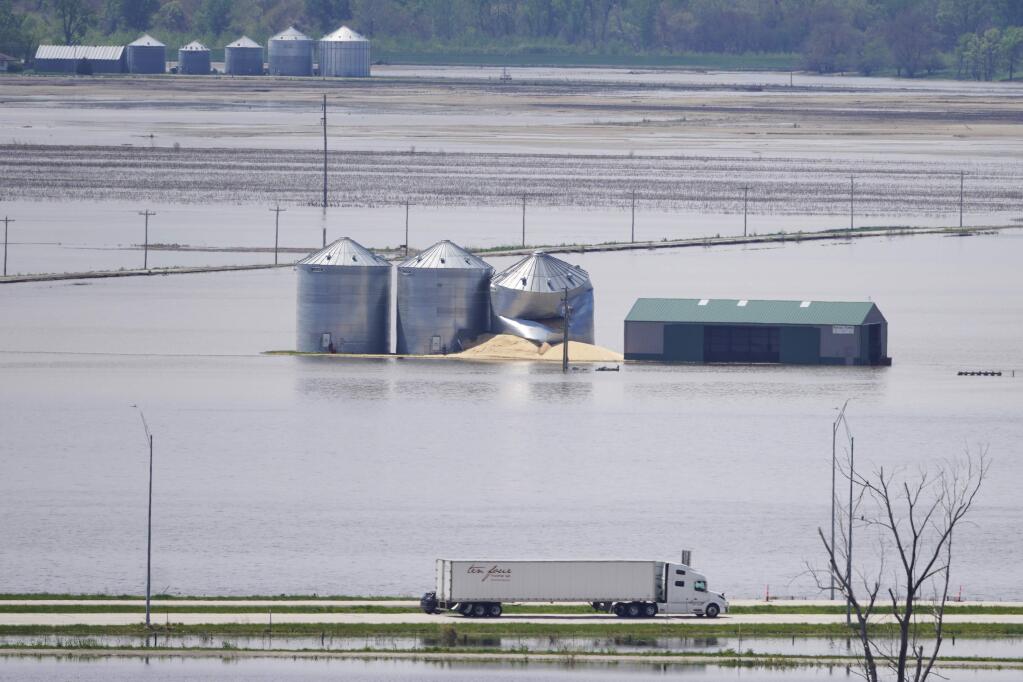 Grain bins stand in floodwaters from the Missouri River, in Hamburg, Iowa, on Friday. The House passed a $19 billion disaster aid bill that would deliver long-sought relief to victims of hurricanes, fires and floods, as Democrats try to dislodge the legislation from a Senate logjam over aid to hurricane-slammed Puerto Rico. (NATI HARNIK / Associated Press)