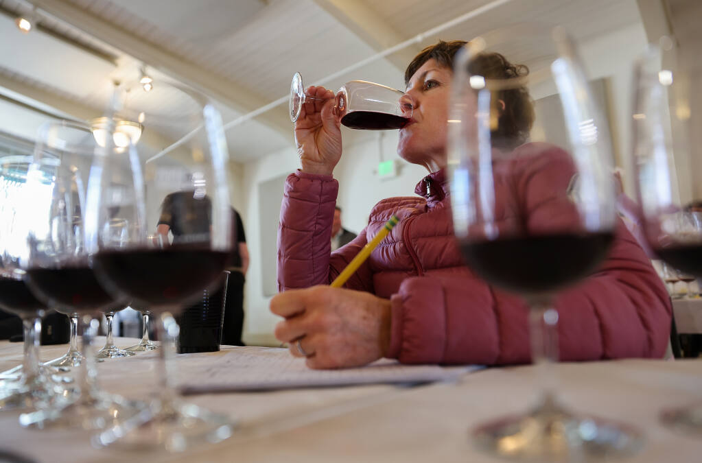 Erin Miller, wine director of Dry Creek Kitchen, tastes a glass of wine during judging at the North Coast Wine Challenge in Santa Rosa on Tuesday, April 5, 2022.  (Christopher Chung/ The Press Democrat)