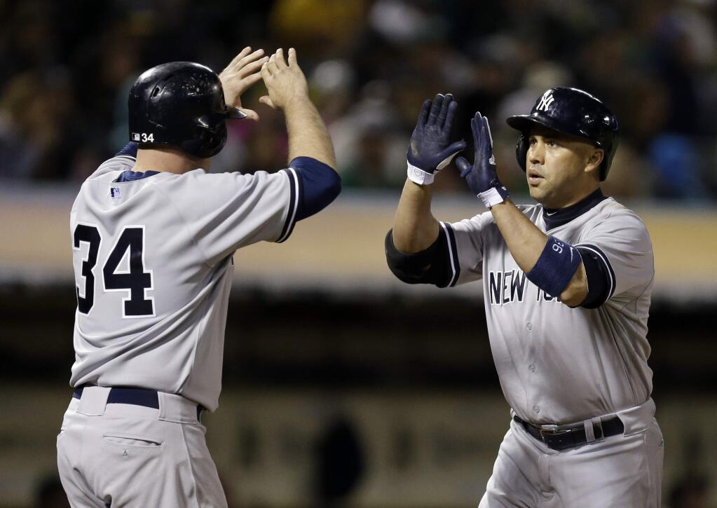 New York Yankees' Carlos Beltran, right, celebrates with Brian McCann (34) after Beltran hit a two-run home run off Oakland Athletics' Jesse Hahn in the sixth inning of a game Saturday, May 30, 2015, in Oakland. (AP Photo/Ben Margot)