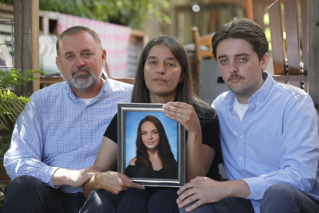 Frank, from left, and Trinity Pellkofer with their son, Evan, show a photo of their daughter Georgia, 25, who died July 21 from complications related to a seizure. Photo taken at their home in Petaluma, Calif. on Wednesday, Aug. 3, 2022. (Beth Schlanker / The Press Democrat)