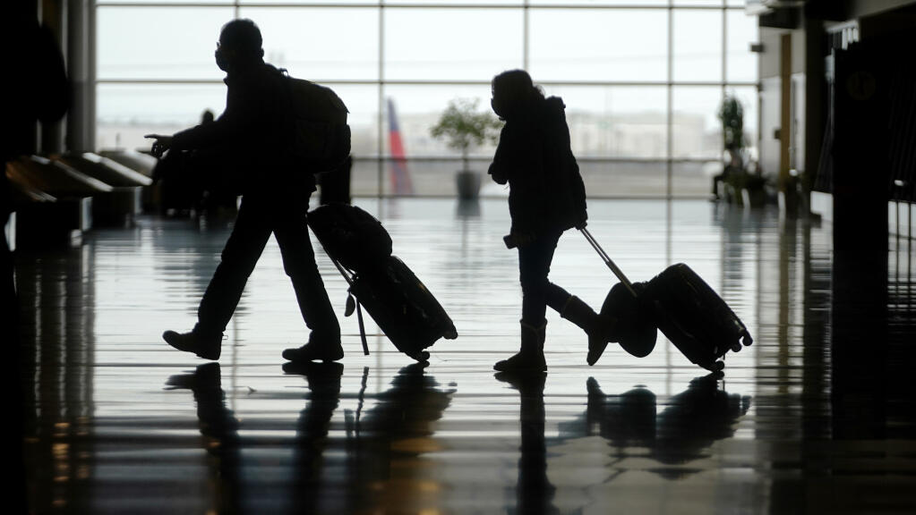 Travelers are shown in Salt Lake City International Airport Tuesday, March 9, 2021, in Salt Lake City. (AP Photo/Rick Bowmer)