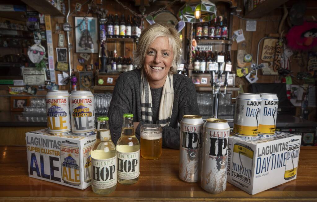 Lagunitas Brewing Co. CEO Maria Stipp with product lines for the Petaluma company, from left, Super Cluster, a citra-hopped mega ale, Hop sparkling water, cans for their flagship IPA and DayTime, a 98-calorie low alcohol IPA. (JOHN BURGESS/ THE PRESS DEMOCRAT, 2019)