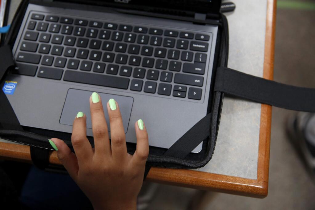 Yessenia Resendiz, 13, uses her laptop during lunch period in the library at Petaluma Jr. High School on Monday, October 6, 2014 near Petaluma, California. (BETH SCHLANKER/ The Press Democrat)