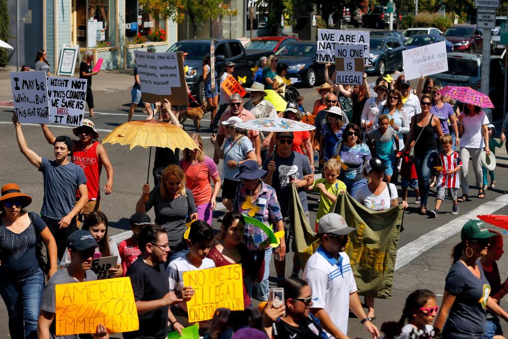 Demonstrators march across the intersection of Howard Street and Western Avenue to protest the repeal of the Delayed Action for Childhood Arrivals (DACA) program and to show their support for dreamers and all immigrants, in Petaluma, California on Sunday, Sept. 10, 2017. (ALVIN JORNADA/ PD)